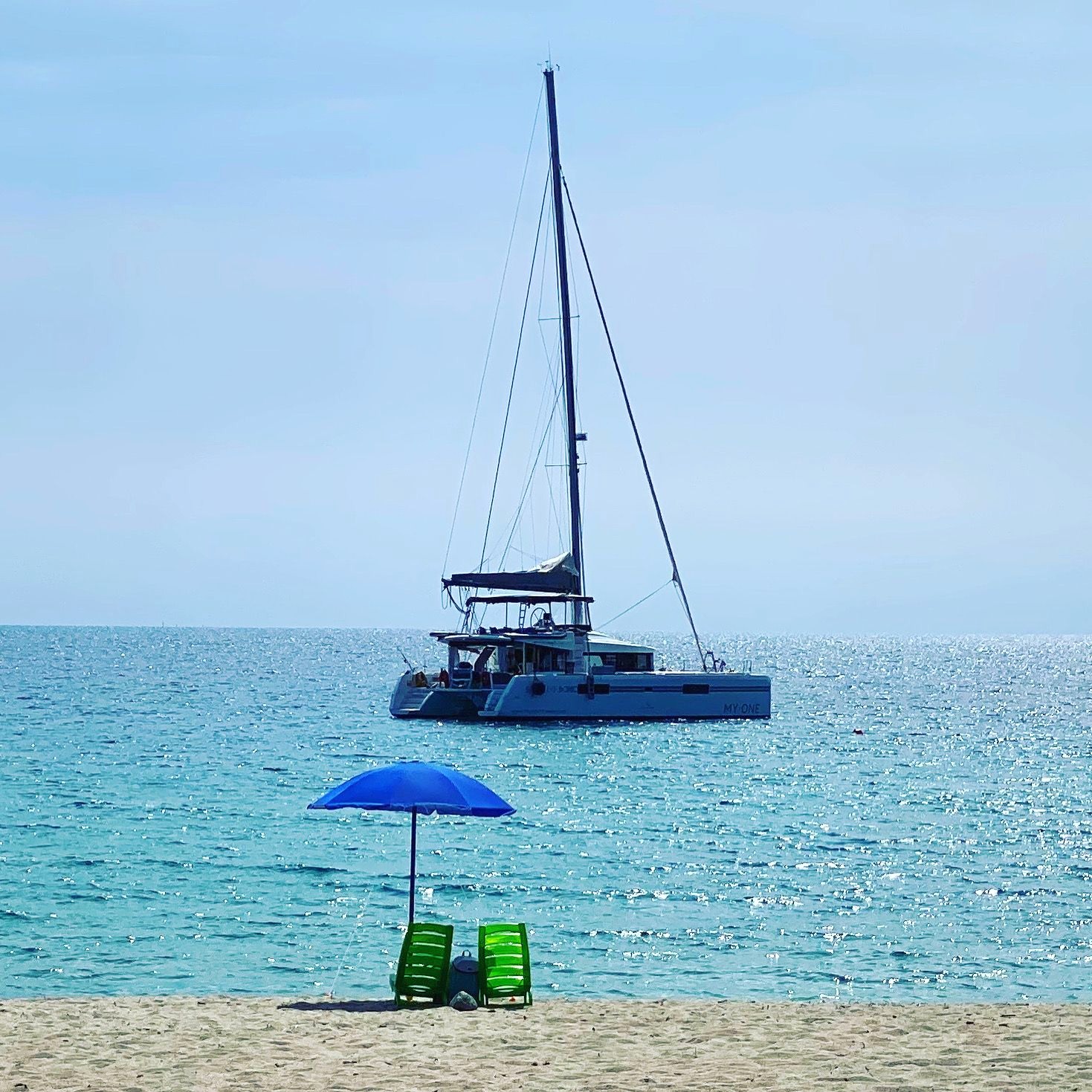 MY·ONE frente a una playa de arena con sombrilla